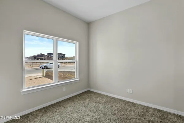 an empty room with closet and windows