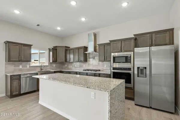 a kitchen with stainless steel appliances granite countertop a sink stove and refrigerator
