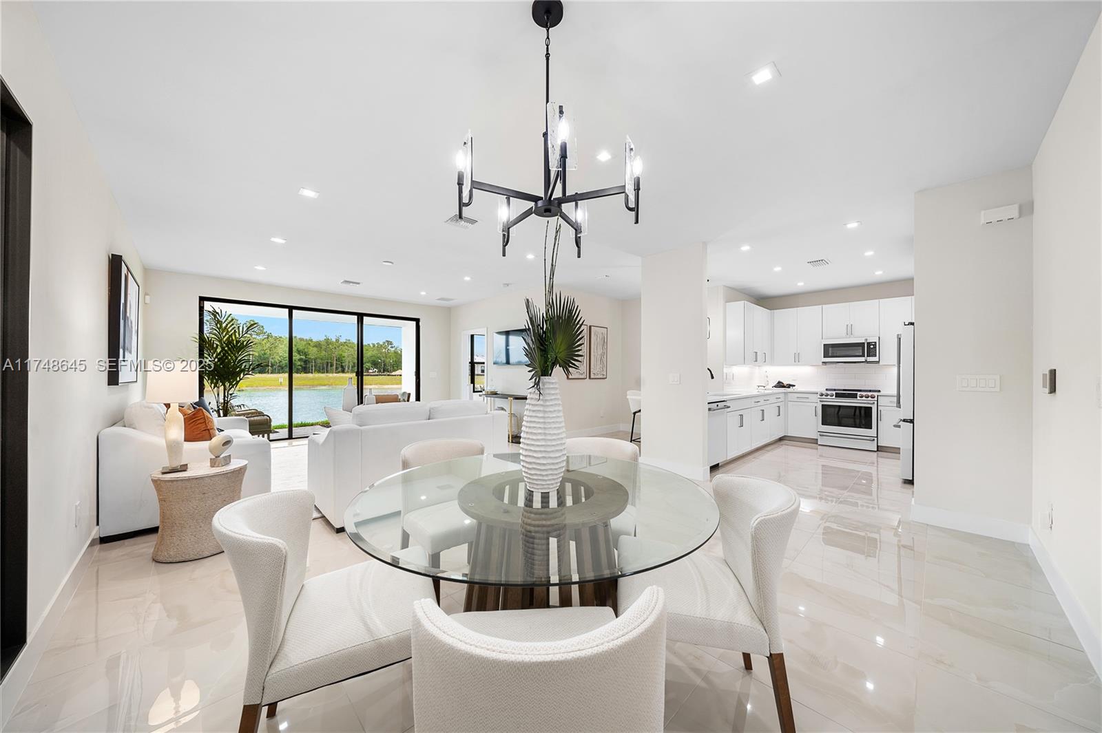 10951 Salt Bay Way Fort Myers, FL 33913 - Photo 30 of 34 a living room with couch a dining table and a chandelier