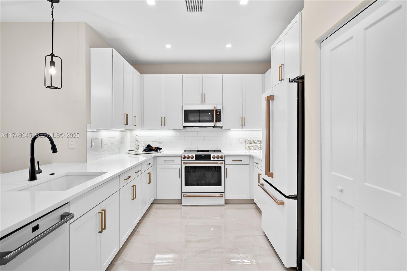 10951 Salt Bay Way Fort Myers, FL 33913 - Photo 10 of 34 a kitchen with stainless steel appliances a refrigerator sink and white cabinets
