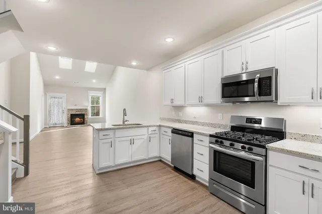 a kitchen with stainless steel appliances granite countertop a stove a refrigerator and a microwave