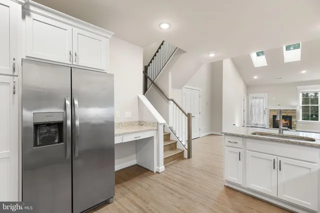 a kitchen with granite countertop a sink cabinets and stainless steel appliances