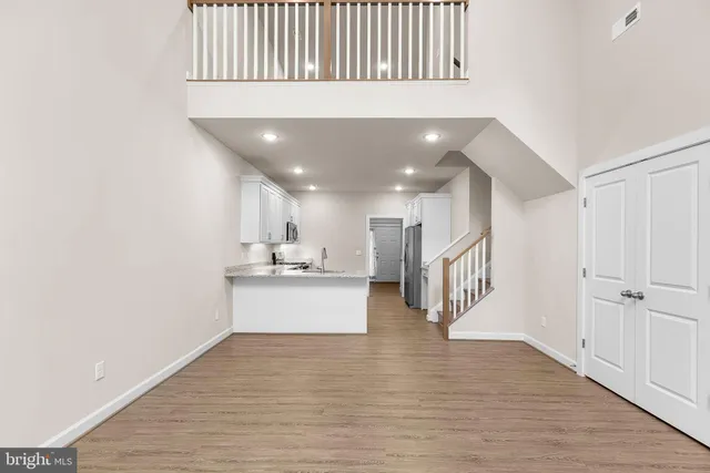 a view of an empty room with wooden floor fireplace and a window