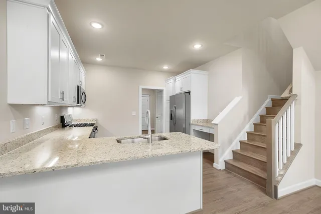 an empty room with wooden floor fireplace and windows