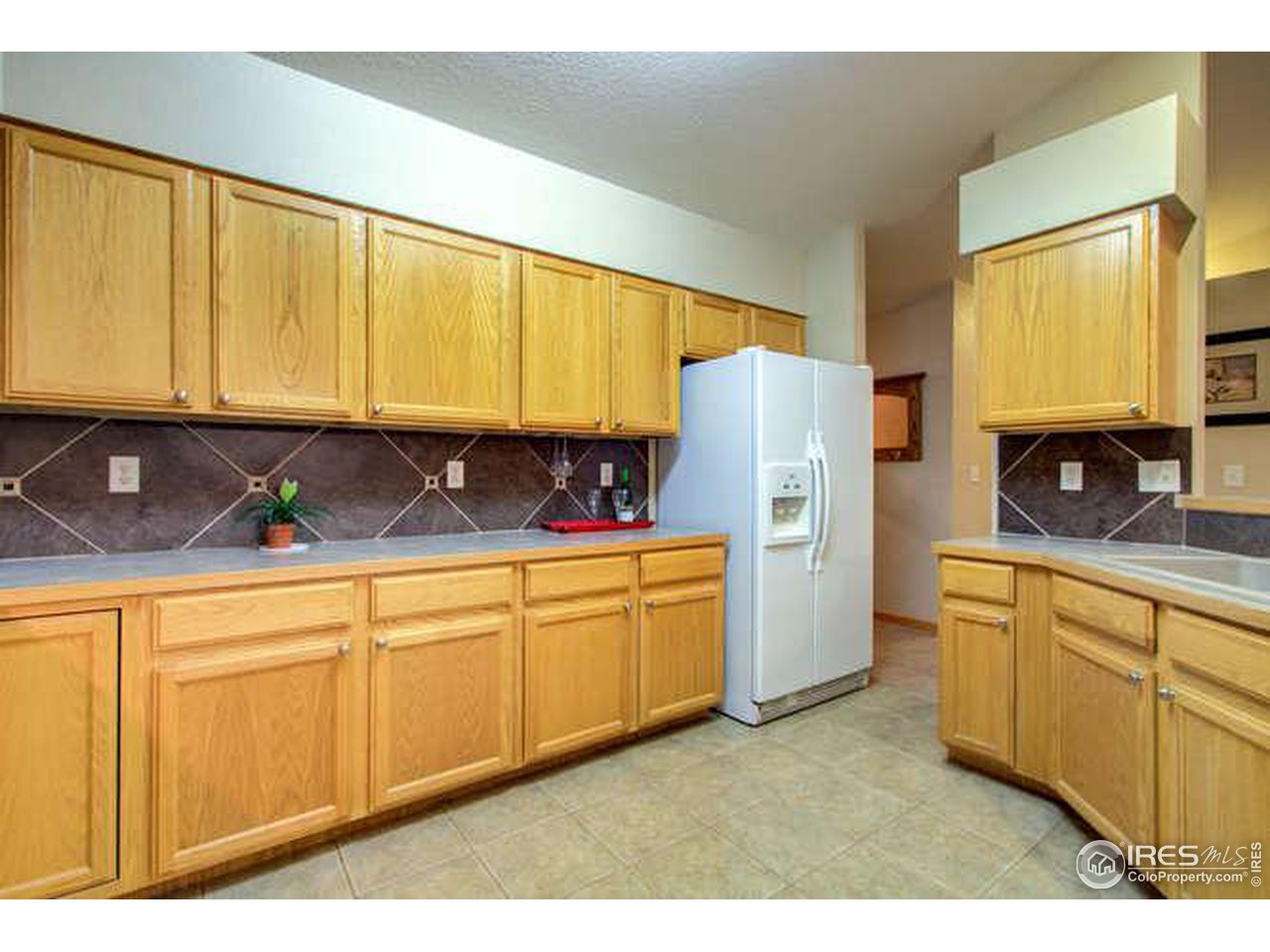 841 Durum Street Windsor, CO 80550 - Photo 19 of 24 a kitchen with granite countertop white cabinets sink and a stove top oven