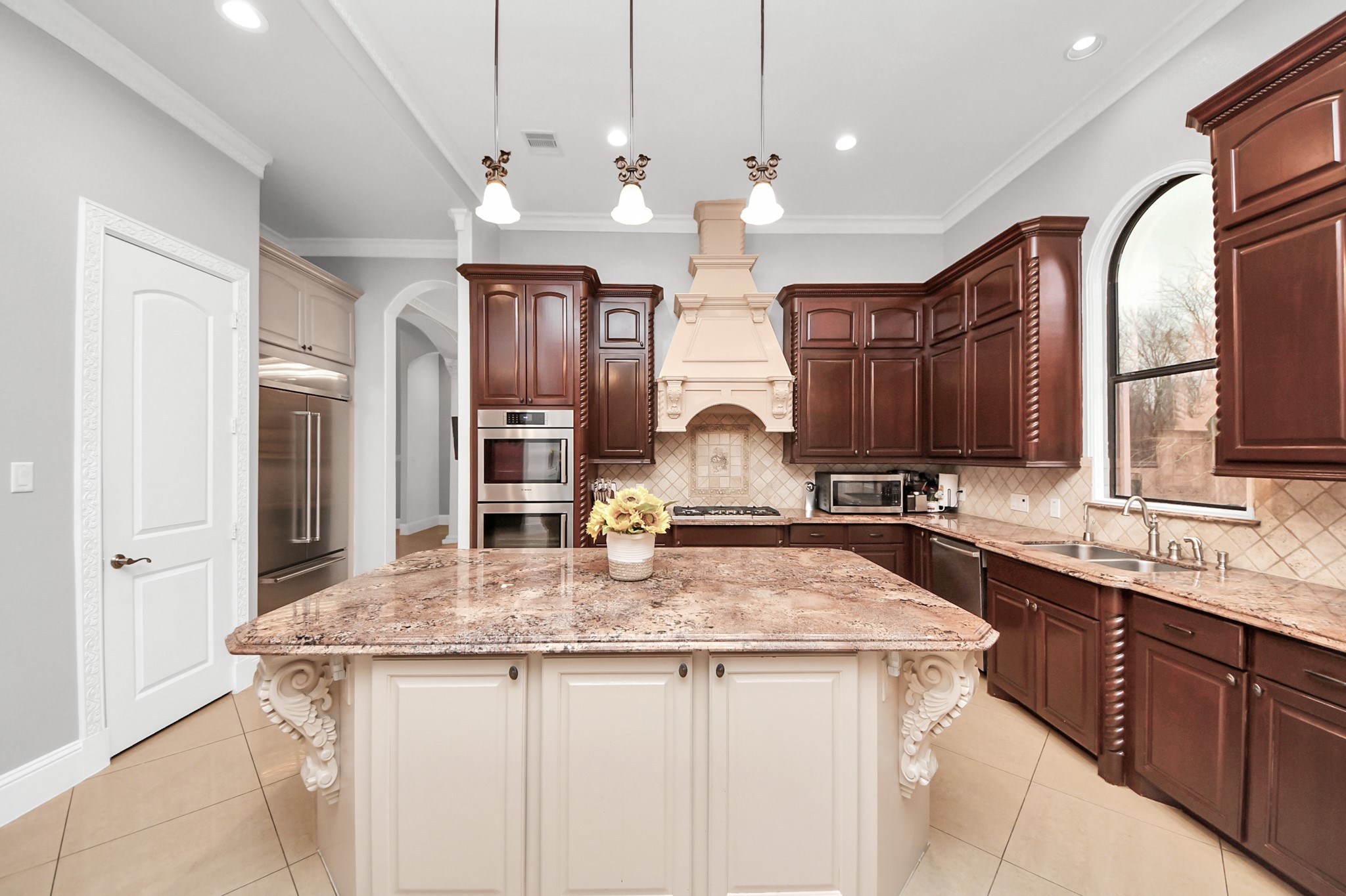 11503 Renaissance Drive Montgomery, TX 77356 - Photo 9 of 50 Chef’s kitchen featuring an oversized island with decorative detailing, granite countertops, custom cabinetry, professional-grade appliances, and an architectural vent hood. Open sightlines and abundant lighting make this space ideal for everyday living and entertaining.