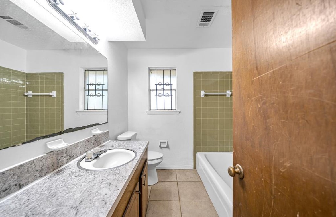 8447 Sterlingshire Street Houston, TX 77078 - Photo 17 of 26 a bathroom with a sink double vanity granite tub shower and a mirror