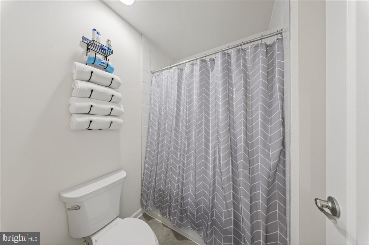 38023 Cross Gate Road Millville, DE 19967 - Photo 23 of 37 a white toilet sitting next to a shower curtain