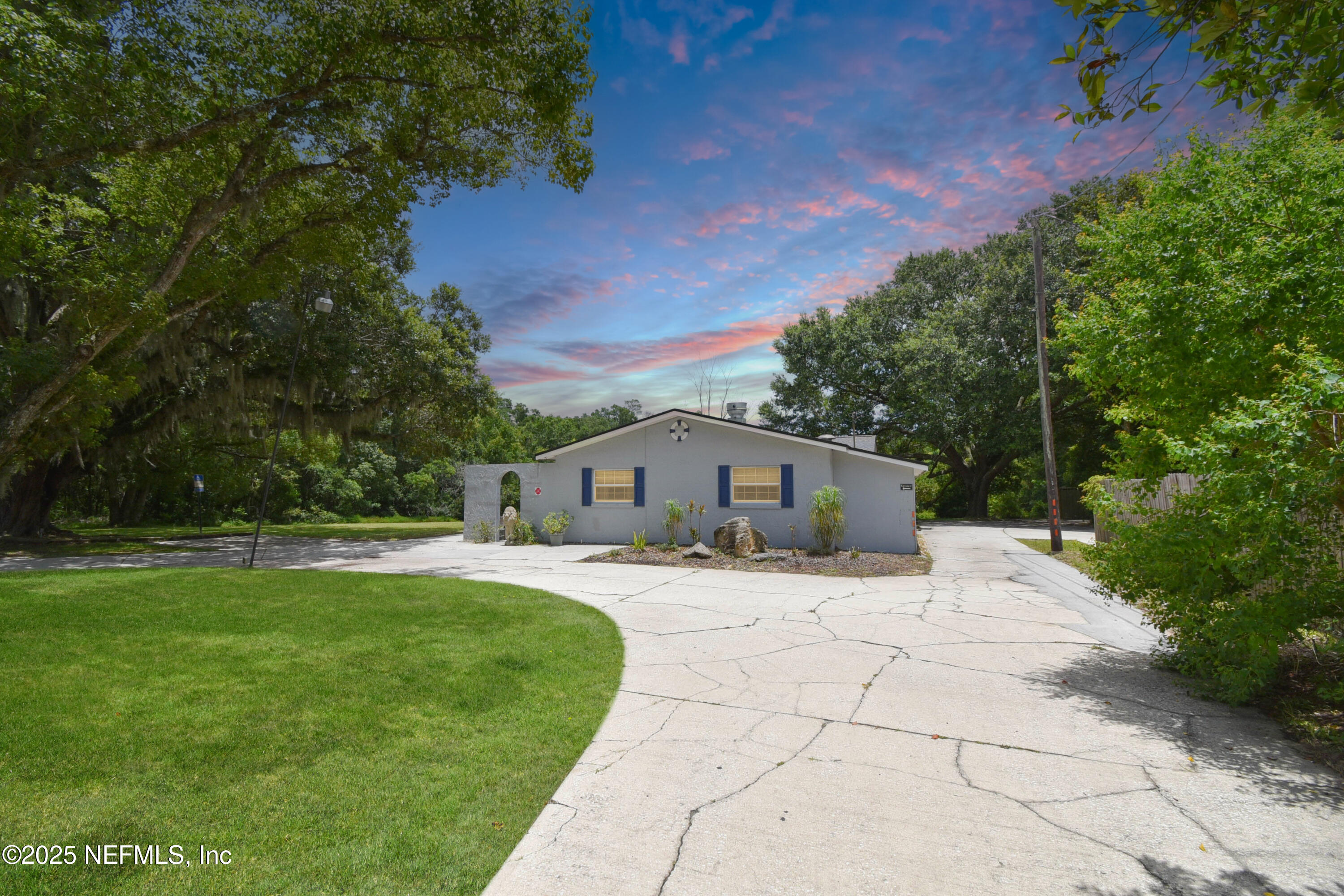 a front view of a house with a yard and trees