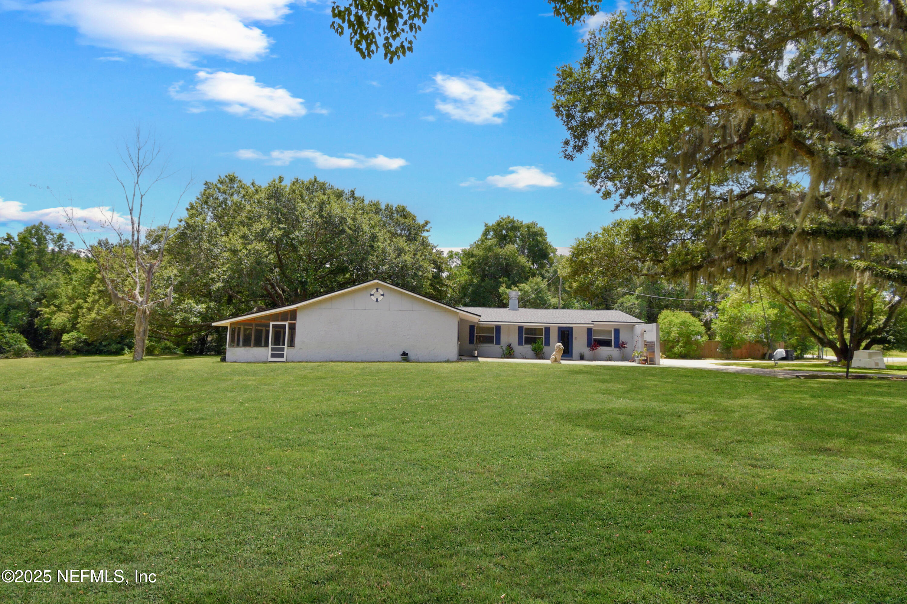 2706 Old Moultrie Road St. Augustine, FL 32086 - Photo 26 of 31 a house that is sitting in the grass with large trees and plants
