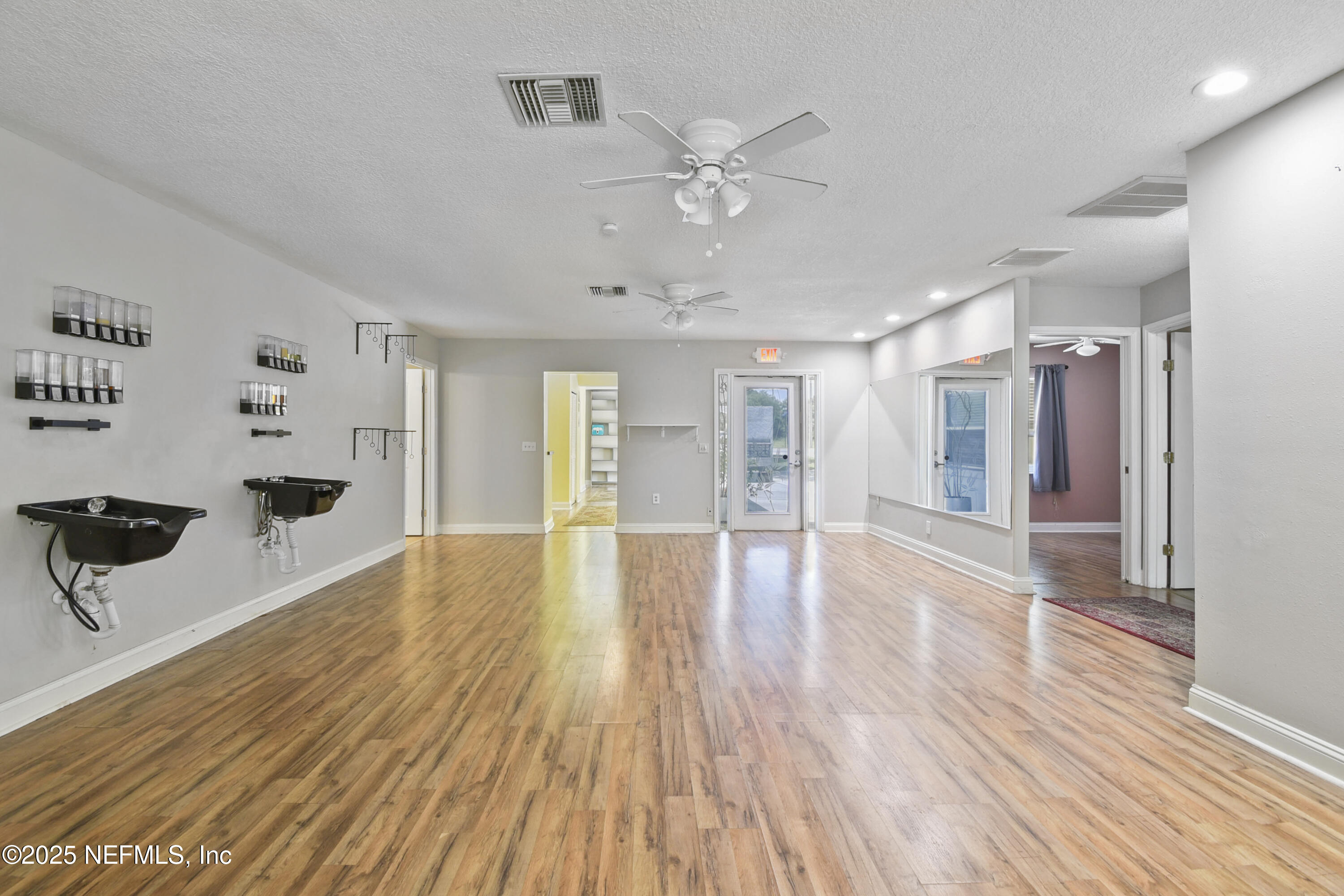 2706 Old Moultrie Road St. Augustine, FL 32086 - Photo 6 of 31 a view of an empty room with wooden floor and a ceiling fan