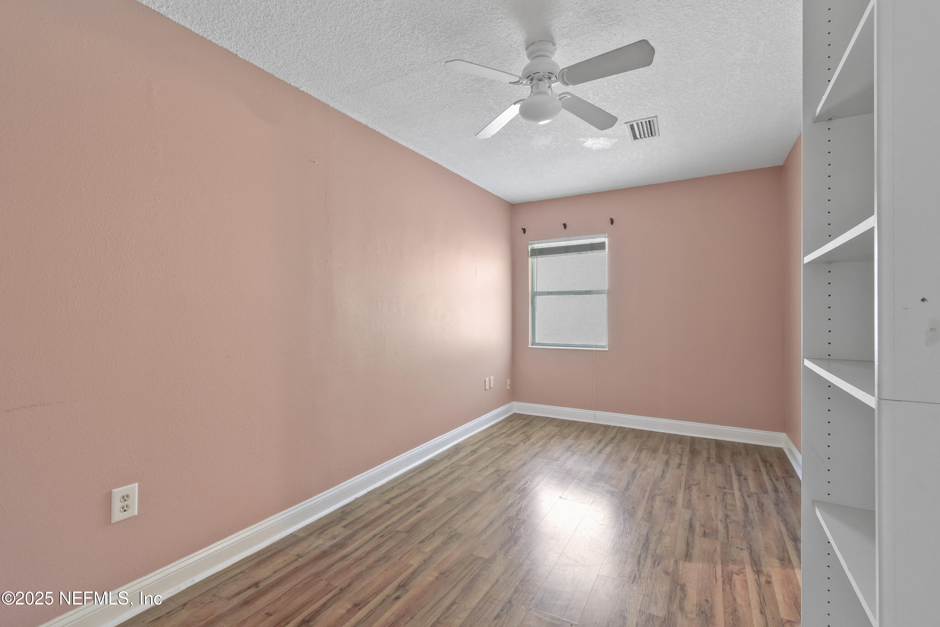 2706 Old Moultrie Road St. Augustine, FL 32086 - Photo 9 of 31 an empty room with wooden floor chandelier fan and windows