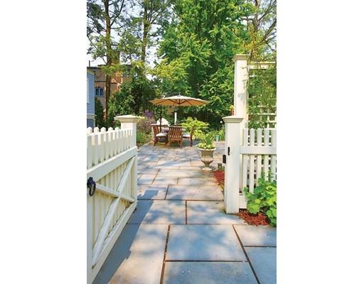 145 Middlesex Road Brookline, MA 02467 - Photo 22 of 25 a view of a patio with table and chairs under an umbrella with large trees
