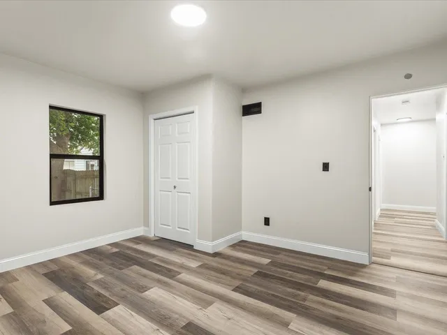 a view of a livingroom with wooden floor and window