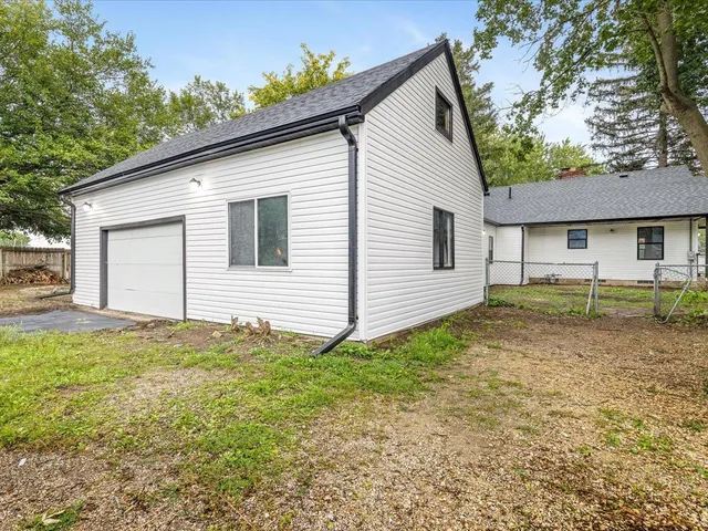 a view of a house with backyard and trees