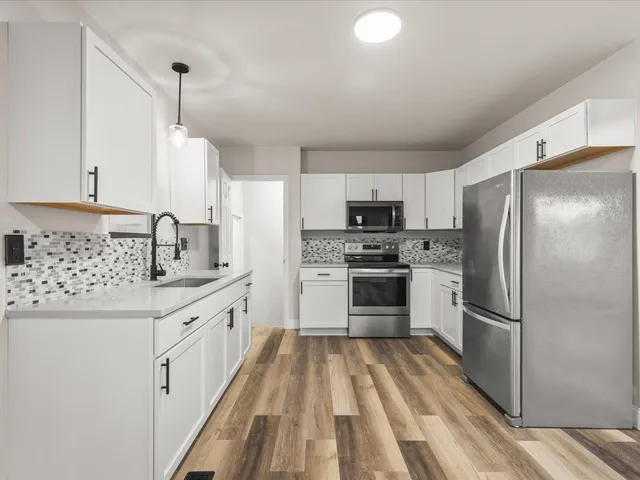 a kitchen with a refrigerator stove and sink