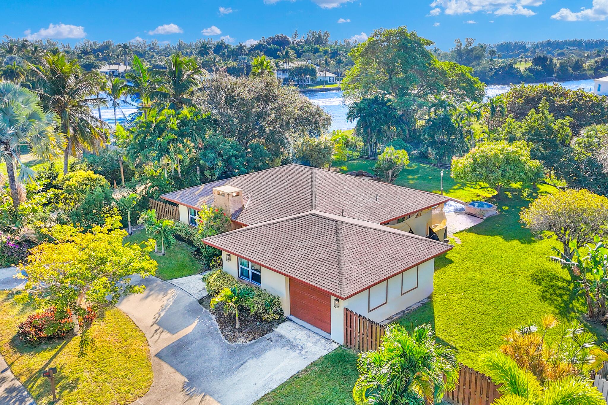 an aerial view of a house with swimming pool and large trees