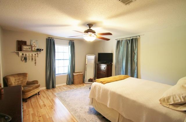 223 Ridge Lake Road Crestview, FL 32536 - Photo 29 of 40 a spacious bedroom with a bed and a chandelier