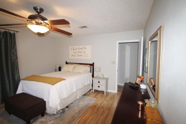 223 Ridge Lake Road Crestview, FL 32536 - Photo 30 of 40 a bedroom with a bed and a chandelier