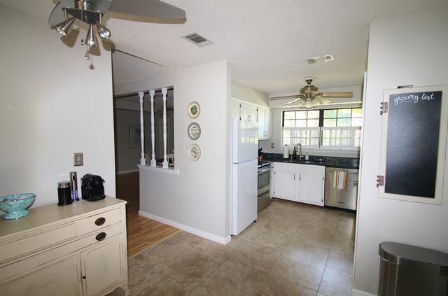 223 Ridge Lake Road Crestview, FL 32536 - Photo 37 of 40 a kitchen with stainless steel appliances a refrigerator and a stove top oven