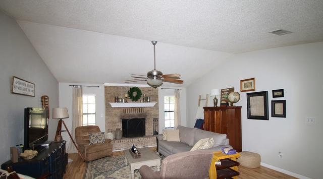 223 Ridge Lake Road Crestview, FL 32536 - Photo 6 of 40 a living room with furniture a flat screen tv and a fireplace