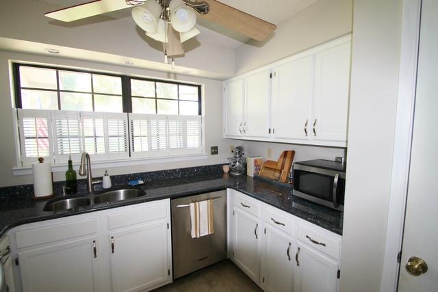 223 Ridge Lake Road Crestview, FL 32536 - Photo 7 of 40 a kitchen with granite countertop white cabinets white appliances a sink and a window