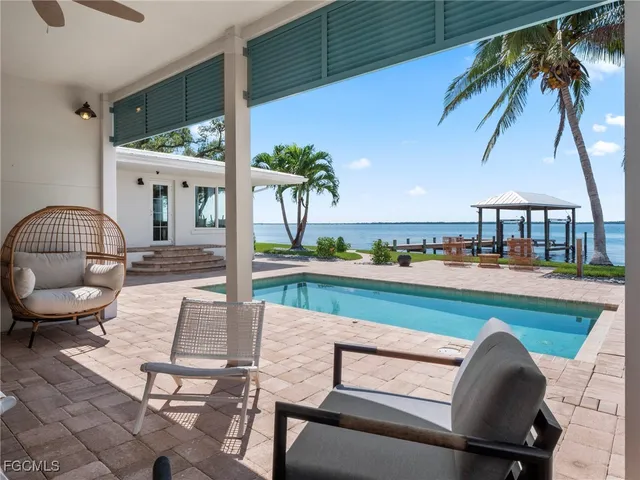 a patio with table and chairs and potted plants