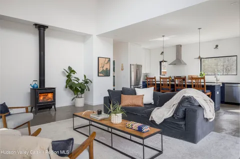 a living room with furniture kitchen view and a potted plant