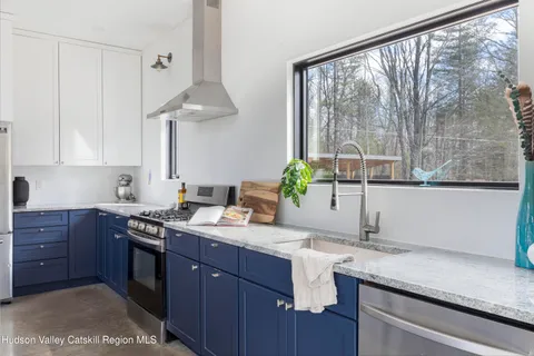 a kitchen with stainless steel appliances granite countertop a sink a stove and a wooden cabinets