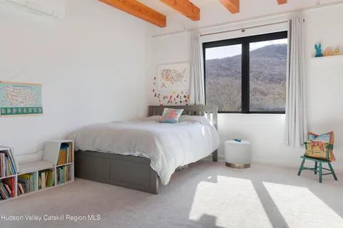 a bedroom with a bed and a large window