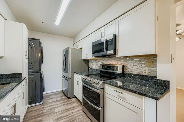 a kitchen with stainless steel appliances granite countertop a stove microwave and refrigerator