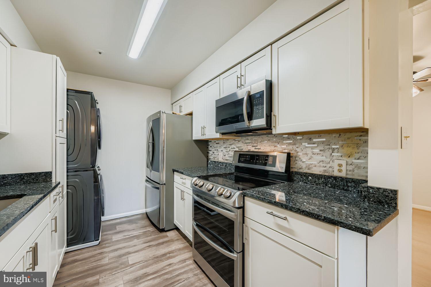 8385 Montgomery Run Road, Unit C Ellicott City, MD 21043 - Photo 5 of 11 a kitchen with stainless steel appliances granite countertop a stove microwave and refrigerator