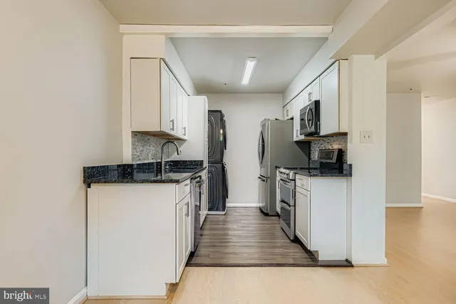 a kitchen with stainless steel appliances granite countertop a refrigerator a stove top oven a sink and dishwasher