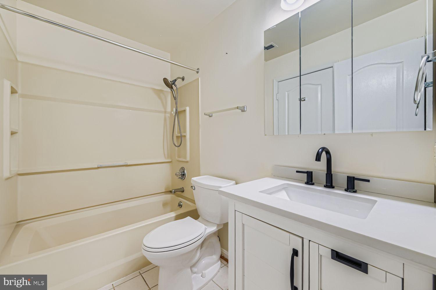 8385 Montgomery Run Road, Unit C Ellicott City, MD 21043 - Photo 8 of 11 a bathroom with a sink a toilet and shower