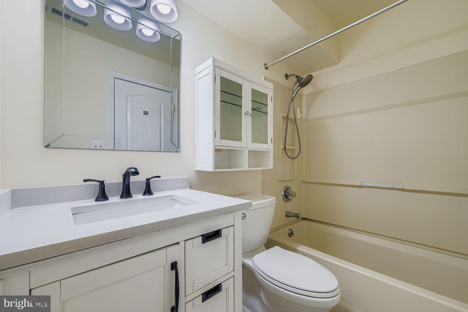 8385 Montgomery Run Road, Unit C Ellicott City, MD 21043 - Photo 10 of 11 a bathroom with a granite countertop sink toilet and shower