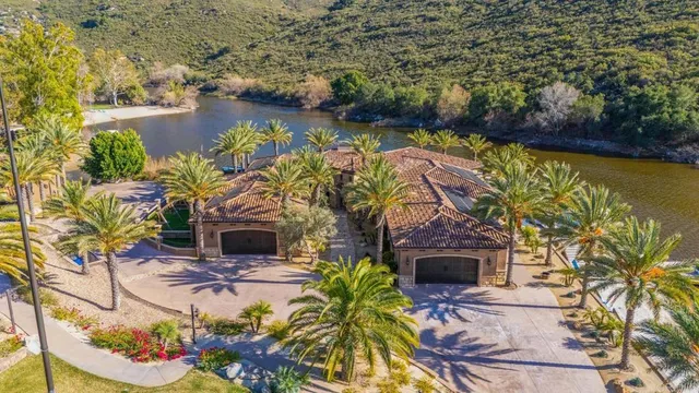 an aerial view of a house with a garden and lake view