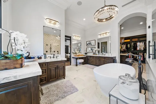 a very nice looking kitchen with granite countertop a stove a sink a dining table and chairs