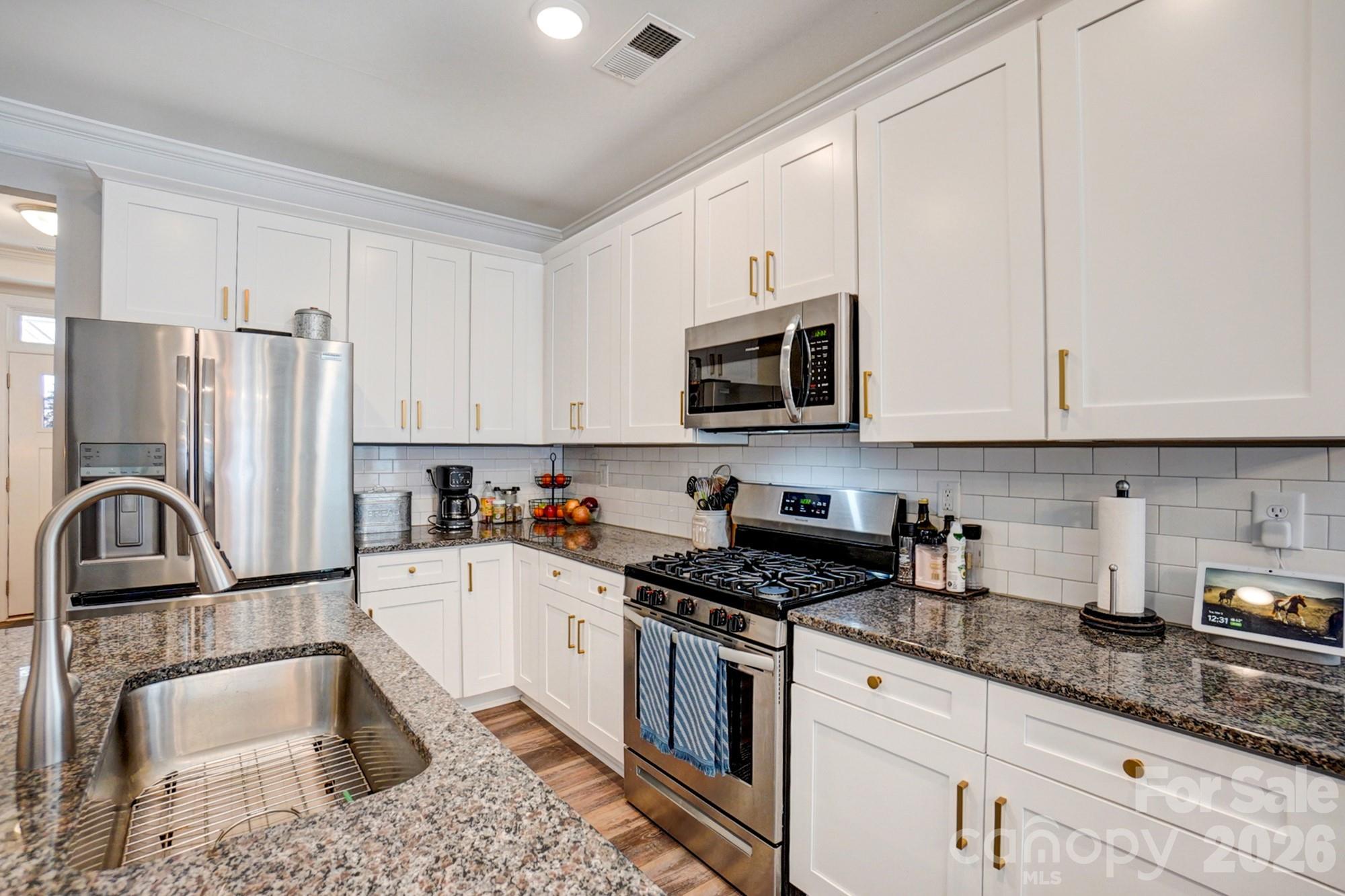 3925 Rothwood Lane Harrisburg, NC 28075 - Photo 9 of 48 a kitchen with granite countertop a sink a window and stainless steel appliances