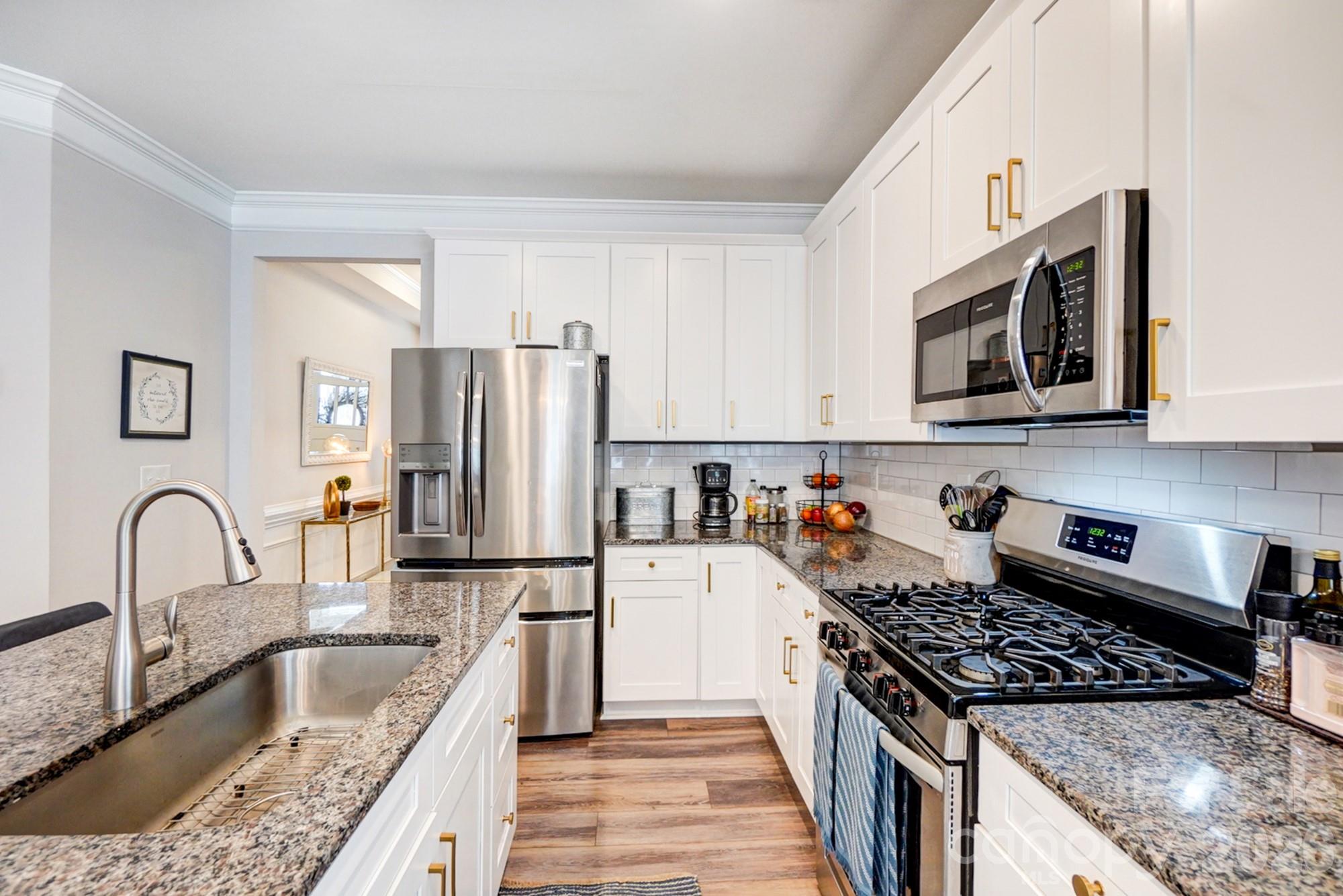 3925 Rothwood Lane Harrisburg, NC 28075 - Photo 10 of 48 a kitchen with granite countertop a refrigerator stove and sink