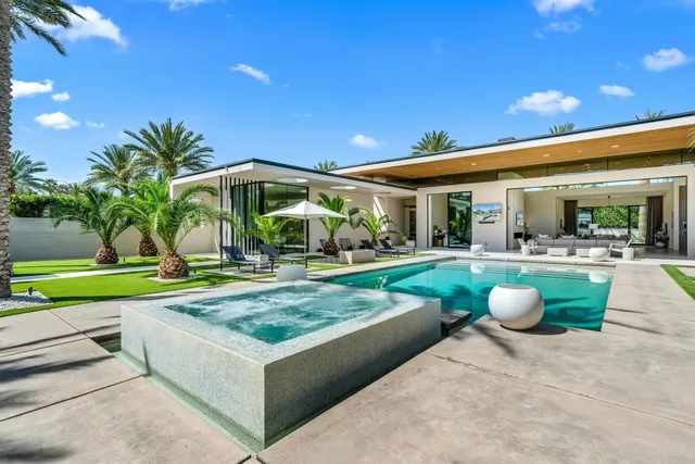 a view of a patio with couches and table and chairs under an umbrella