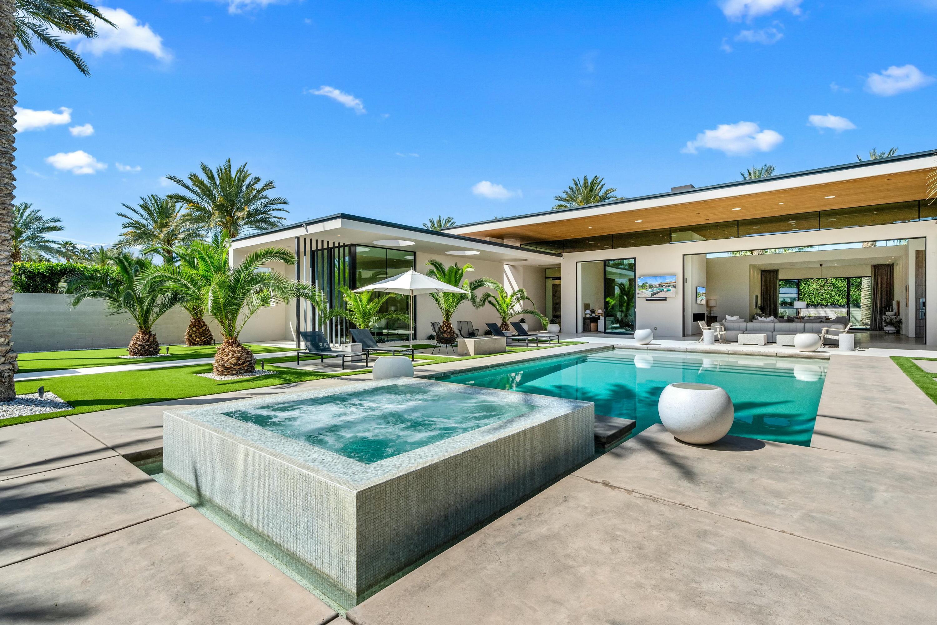 3 Makena Lane Rancho Mirage, CA 92270 - Photo 36 of 38 a view of a patio with couches and table and chairs under an umbrella