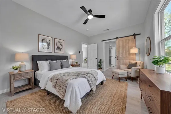 a spacious bedroom with a bed and wooden floor