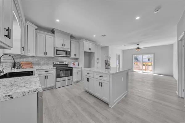 a kitchen with granite countertop white cabinets and white appliances