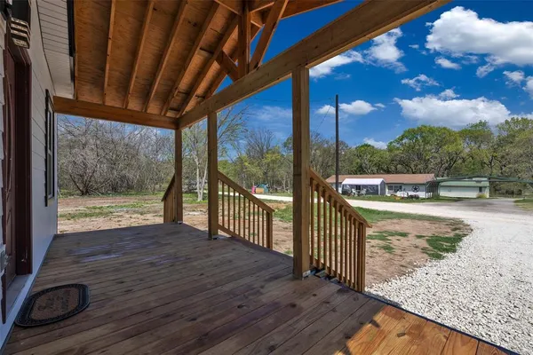 a view of a porch with wooden floor and fence