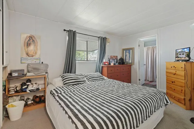 a bedroom with a bed and dresser with mirror