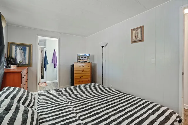 a bedroom with a bed and a lamp on dresser