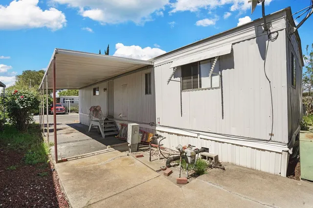 a backyard of a house with table and chairs