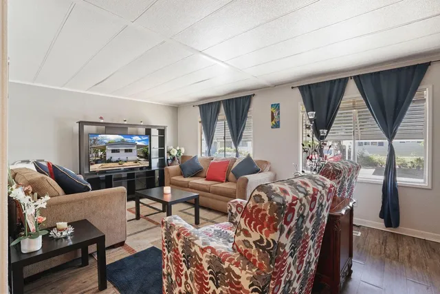 a living room with furniture a rug and a large window