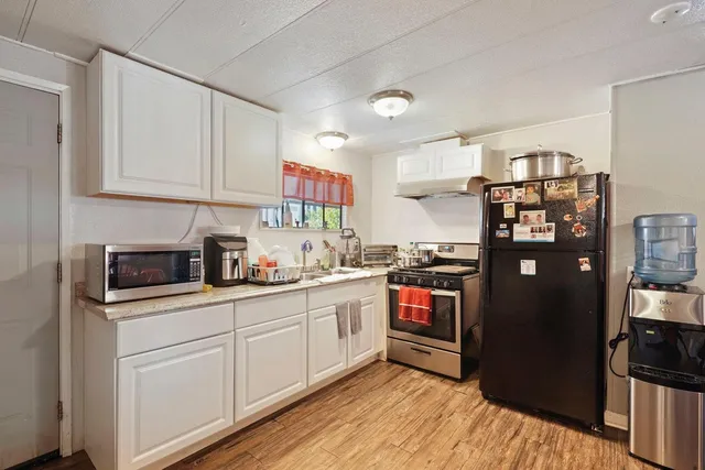 a kitchen with stainless steel appliances granite countertop a refrigerator and a stove