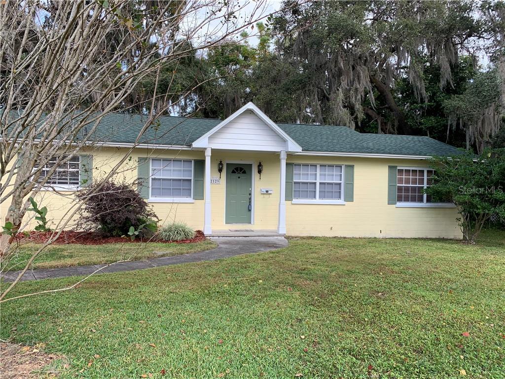 2129 Palmetto Road Mount Dora, FL 32757 - Photo 1 of 1 a front view of a house with a yard and trees